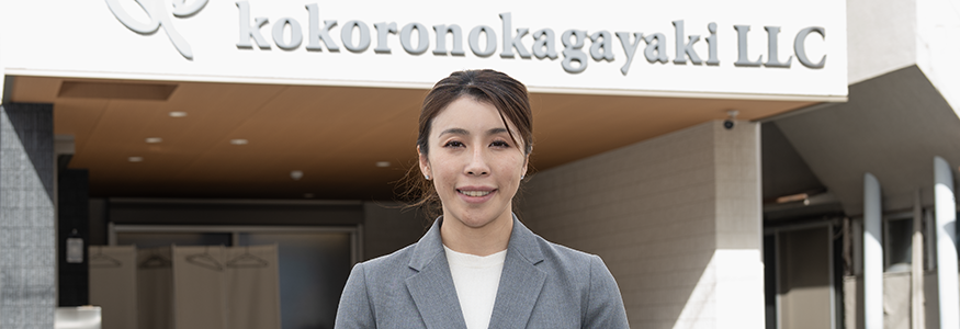 心の輝き合同会社の代表者が会社の前に立っている写真